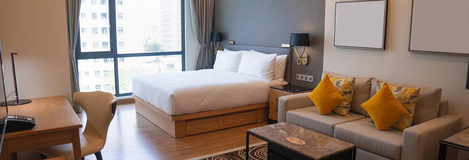 Hotel room with a wood bed frame, headboard wall and built-in furniture