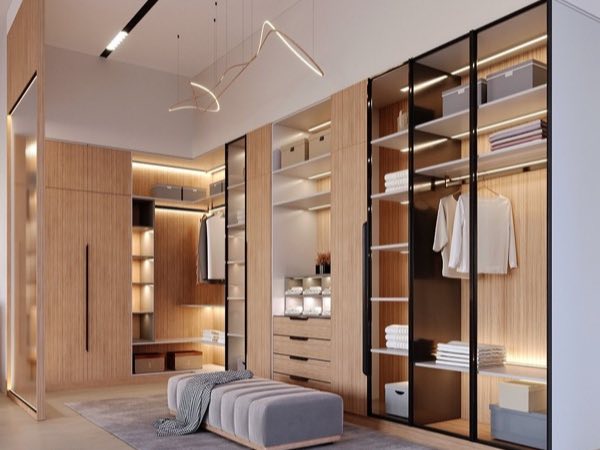 Walk-in closet with black-framed glass doors and a bench