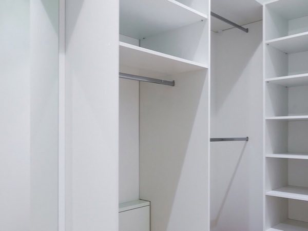 White built-in closet with hanging rails and shelves