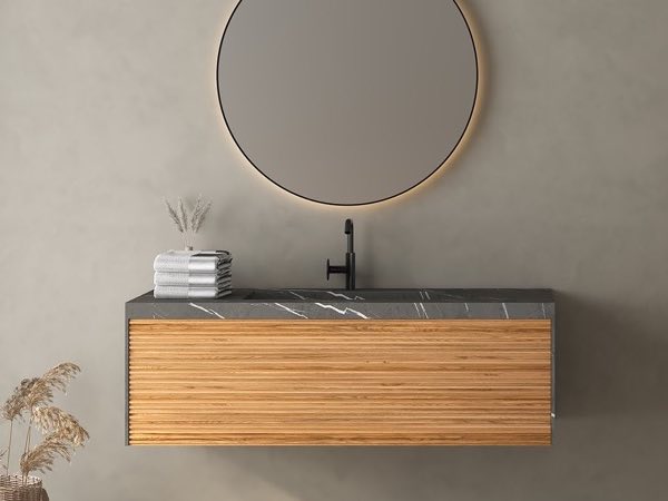 Oak floating vanity with a dark stone top and a round mirror